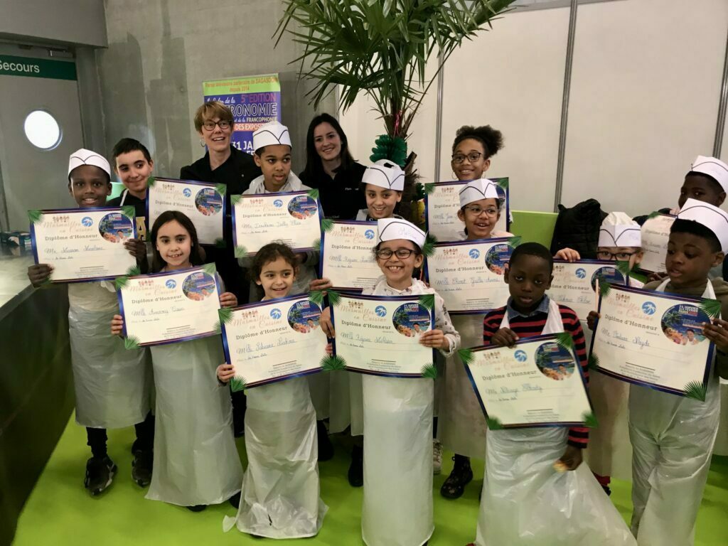 Enfants participants à un atelier cuisine recevant leur diplôme lors d’une animation culinaire